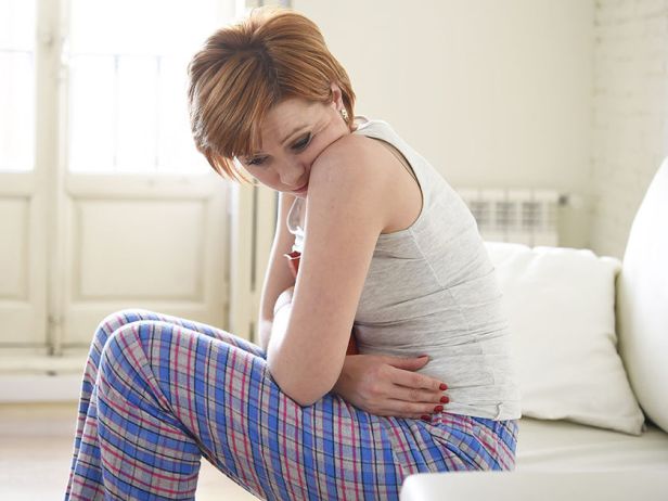 sad-young-woman-holding-stomach